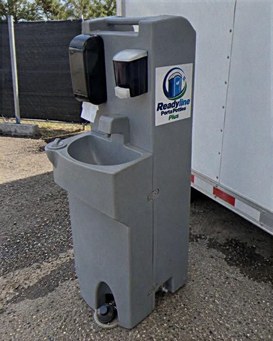 Grey hand-wash station next to a white box truck backstage at an event